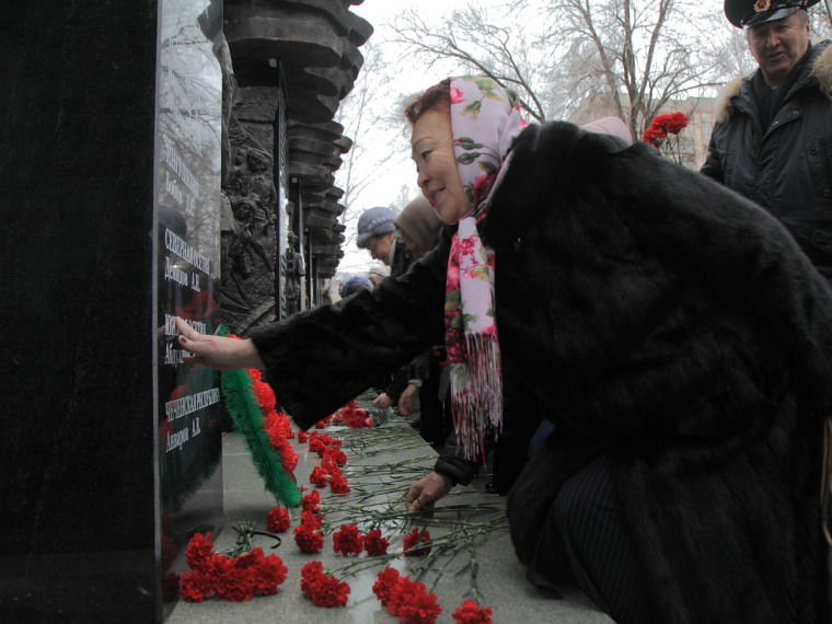 Мать Героя России Раушана Абдуллина прикасается к выбитой на мемориальной плите фамилии сына 